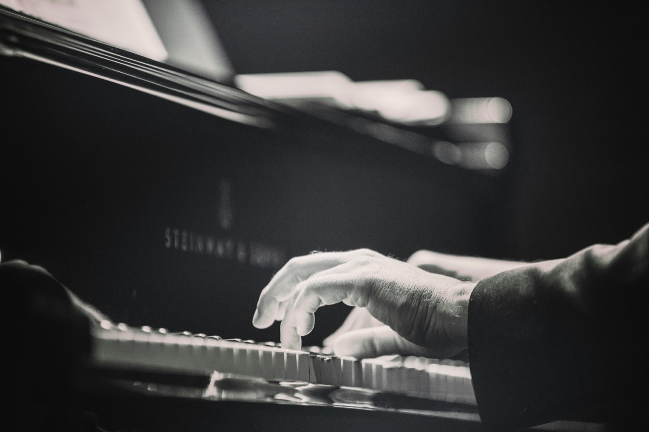 Hands playing a keyboard, comparing major and minor scales.